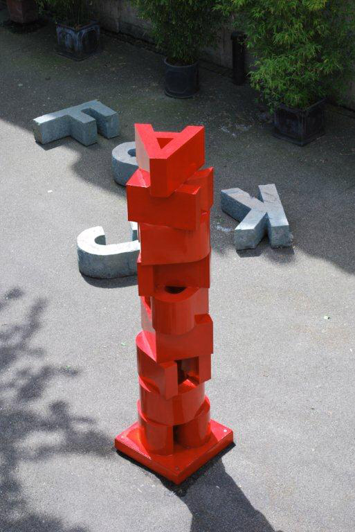 Rote Skulptur aus gestapelten Buchstaben von oben gesehen